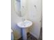 Pedestal sink beneath an oval mirror in modern bathroom with wood-look floors at 2761 Frosted Teal Ave, North Las Vegas, NV 89086