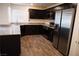 Modern kitchen with dark cabinets, stainless steel appliances, granite countertops, and wood-style flooring at 2761 Frosted Teal Ave, North Las Vegas, NV 89086