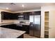 Modern kitchen with stainless steel appliances, dark cabinetry, and granite countertops at 2761 Frosted Teal Ave, North Las Vegas, NV 89086