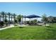 Community playground featuring green grass, shade structures, and modern play equipment for enjoyment at 2761 Frosted Teal Ave, North Las Vegas, NV 89086
