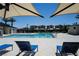 Community pool and lounge area, perfect for relaxation with its sun umbrellas, chaise lounges and palm trees at 2761 Frosted Teal Ave, North Las Vegas, NV 89086
