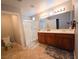 Bright bathroom with a dual sink vanity, tile floors, and a glass-enclosed shower at 2840 China Cove St, Laughlin, NV 89029