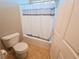 Clean bathroom featuring a toilet and shower-tub with neutral-colored shower curtain at 2840 China Cove St, Laughlin, NV 89029