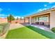 Backyard featuring a covered patio, artificial turf, and desert landscaping at 2910 Monate Ct, Henderson, NV 89044
