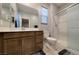Bathroom with marble countertops, wood vanity, shower, and window with privacy blinds at 2910 Monate Ct, Henderson, NV 89044
