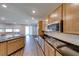 Modern kitchen features a large island, stainless appliances, gas cooktop, wood cabinets and view to the living area at 2910 Monate Ct, Henderson, NV 89044