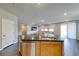 Kitchen area with stainless steel appliances, wood cabinets, granite counters, island and view to the living room at 2910 Monate Ct, Henderson, NV 89044
