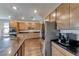 Large kitchen with stainless steel appliances, wood cabinetry, granite countertops, and sizable island at 2910 Monate Ct, Henderson, NV 89044