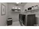 Laundry room featuring front-load washer and dryer, shelving and stylish decor at 2910 Monate Ct, Henderson, NV 89044