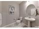 Powder room featuring a pedestal sink, round mirror, neutral paint and decor at 2910 Monate Ct, Henderson, NV 89044
