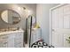 Bathroom with white vanity, double sinks, round mirrors, decorative lights, and black and white tiled flooring at 3481 Winery Rd, Pahrump, NV 89048
