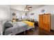Bright bedroom with wood floors, dresser, and a comfortable bed with yellow accents at 3481 Winery Rd, Pahrump, NV 89048