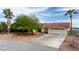 Exterior home showcasing desert landscaping, tile roof, and a two-car garage with a long driveway at 3481 Winery Rd, Pahrump, NV 89048