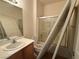 Cozy bathroom featuring a shower-tub combo with sliding glass doors, toilet, and single sink vanity at 3508 Kittiwake Rd, North Las Vegas, NV 89084