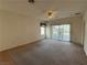 Open living room with carpeted area, ceiling fan and sliding glass doors to the backyard at 3508 Kittiwake Rd, North Las Vegas, NV 89084