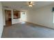 Spacious living room featuring carpet, ceiling fan, and an open layout with access to the kitchen at 3508 Kittiwake Rd, North Las Vegas, NV 89084