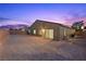 Exterior view of a backyard at dusk with sliding glass door and brick perimeter at 3706 Etendre Ct, Las Vegas, NV 89121