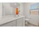 Well-lit bathroom features a single sink vanity, toilet, mirror, and combination shower-tub with bright orange curtain at 3706 Etendre Ct, Las Vegas, NV 89121