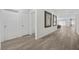 Bright hallway with wood floors, white doors, and stylish art leading to an open living area at 3706 Etendre Ct, Las Vegas, NV 89121