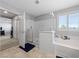 Bright bathroom features a glass shower, soaking tub, and shuttered window for natural light at 3854 Stadium Ave, Las Vegas, NV 89120