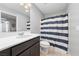 Bathroom featuring dark wood cabinets, white countertops and a blue and white shower curtain at 3854 Stadium Ave, Las Vegas, NV 89120