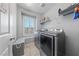Laundry room equipped with modern washer and dryer, window with shutters, and storage options at 3854 Stadium Ave, Las Vegas, NV 89120