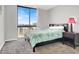 This bedroom boasts a city view window, gray walls, and a side table with lamp at 3930 University Center Dr # 603, Las Vegas, NV 89119
