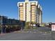 View of the condo building with a secured gate entrance and manicured landscaping under a clear sky at 3930 University Center Dr # 603, Las Vegas, NV 89119