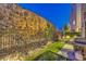 Backyard area with decorative rock wall, artificial grass, stone paver path, and barbecue grill at 414 Tranquil Peak Ct, Henderson, NV 89012