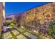 This backyard features a decorative rock wall, artificial grass, and a stone paver path at 414 Tranquil Peak Ct, Henderson, NV 89012