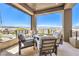 Relaxing covered balcony with seating, a fire pit, and beautiful panoramic views at 414 Tranquil Peak Ct, Henderson, NV 89012