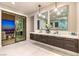 Modern bathroom with double vanity, soaking tub, and sliding doors to balcony with city views at 414 Tranquil Peak Ct, Henderson, NV 89012