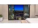 Bedroom featuring sliding glass doors with city views at dusk at 414 Tranquil Peak Ct, Henderson, NV 89012