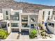 Striking three-story home featuring modern design, balconies, large windows, glass garage doors, and professionally landscaped yard at 414 Tranquil Peak Ct, Henderson, NV 89012