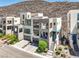 Contemporary home boasting clean lines, multiple balconies, a glass garage door, and manicured landscaping at 414 Tranquil Peak Ct, Henderson, NV 89012