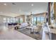 Open-concept living area flows into dining space, with a large sofa, accent chairs, and a sleek fireplace at 414 Tranquil Peak Ct, Henderson, NV 89012