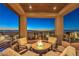 Relaxing patio with a fire pit and beautiful city views at twilight at 414 Tranquil Peak Ct, Henderson, NV 89012