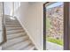Elegant staircase with carpeted steps and view of the landscaped yard at 414 Tranquil Peak Ct, Henderson, NV 89012