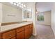Bathroom with a granite counter top, wood cabinets, mirror and a doorway to a carpeted bedroom at 4400 S Jones Blvd # 2033, Las Vegas, NV 89103