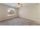 Spacious bedroom with neutral carpet, ceiling fan, and large window at 4400 S Jones Blvd # 2033, Las Vegas, NV 89103
