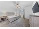 Well-lit main bedroom with carpet, ceiling fan, dresser, and a wall-mounted TV at 485 Pebble Run Ave, Henderson, NV 89011