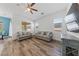 Inviting living room with wood-look floors, neutral furniture, and a modern ceiling fan at 485 Pebble Run Ave, Henderson, NV 89011