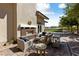 Relaxing outdoor lounge featuring a brick fireplace, comfortable seating, and manicured landscaping at 485 Pebble Run Ave, Henderson, NV 89011