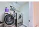 Convenient laundry room featuring modern washer and dryer units and practical shelving at 5502 Cinnamon Ave, Las Vegas, NV 89122