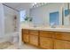 Bright bathroom featuring a shower-tub combination and double sink with wood vanity and light colored flooring at 6436 Deadwood Rd, Las Vegas, NV 89108
