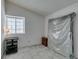 Bright bedroom with a mattress still wrapped, side table and grey carpet, bathed in natural light from the window at 6436 Deadwood Rd, Las Vegas, NV 89108