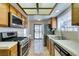 Functional kitchen with tile countertops, wooden cabinets, and a view to the backyard through a sliding glass door at 6436 Deadwood Rd, Las Vegas, NV 89108