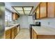 Efficient kitchen with tile countertops, wooden cabinets, and modern appliances, including a stainless steel refrigerator at 6436 Deadwood Rd, Las Vegas, NV 89108