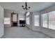 Open-plan living room with a brick fireplace, large windows, and a view of the dining area at 6436 Deadwood Rd, Las Vegas, NV 89108