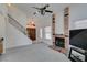 Open living room with a brick fireplace, a staircase with black railing, and a view of the front door at 6436 Deadwood Rd, Las Vegas, NV 89108